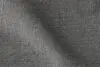 Close-up of a textured black or dark gray woven fabric, showing its fine, grid-like pattern and subtle variations in shading due to folds or lighting.