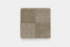 A square fabric swatch divided into four smaller squares, each with a slightly different shade of beige or brown and a textured, woven appearance, displayed on a plain white background.