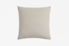 A plain, square beige throw pillow with a subtle woven texture is centered against a white background.