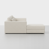 Side view of a modern, light beige sectional sofa with plush cushions and a matching ottoman, set against a plain white background.