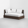 A modern daybed with a dark wooden frame, brown upholstered backrest, and four white pillows placed against the back, set in a minimalist, light-colored room with bare walls and floor.