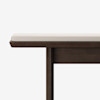 A close-up of a wooden bench with a dark brown finish and a light beige cushioned seat, shown against a plain white background. Only part of the bench is visible.