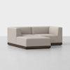 A modern, beige sectional sofa with clean lines and a dark wooden base, arranged in an L-shape on a light-colored floor against a plain white background.