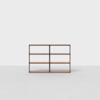 A simple, modern wooden bookshelf with six open shelves, set against a plain white background on a light gray floor.