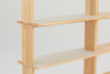 A close-up of a light wood shelving unit with beige felt-covered shelves, shown against a plain white background.