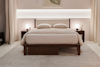 A modern bedroom with a wooden bed frame, beige bedding, two pillows, matching nightstands with round lamps, a soft rug, and neutral curtains, all set against a softly lit wall.