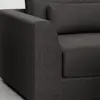 Close-up of a modern dark gray fabric sofa, showing the left armrest, seat cushion, and backrest pillow with clean, minimalist lines.