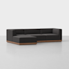 A modern, L-shaped sectional sofa with dark upholstery and a wooden base sits on a plain light gray floor against a white background.