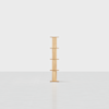 A minimalist wooden shelf with five evenly spaced horizontal surfaces stands alone on a light, reflective floor against a plain white background.