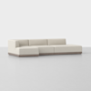 A modern beige sectional sofa with clean lines, low backrests, and a wooden base, set against a plain light gray background.