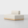 A modern, minimalist beige sofa with a low backrest and wooden base, placed on a light gray floor against a plain white background.