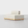 A modern, minimalist beige sofa with a low backrest and wooden base, placed on a light gray floor against a plain white background.