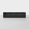 A modern, dark gray three-seat sofa with low armrests and a wooden base, set against a plain white background.