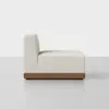A modern armless lounge chair with a textured off-white cushion and a low wooden base, shown from the side against a plain white background.