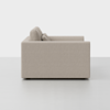 Side view of a modern, light beige sofa with clean lines and square armrests, set against a plain white background. Two back cushions are visible.