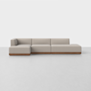 A modern, light beige sectional sofa with a low backrest and wooden base, set against a plain white background on a light-colored floor.