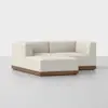 A modern, L-shaped sectional sofa with light beige upholstery and a wooden base, set against a plain white background.
