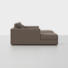 A side view of a modern, brown sectional sofa with plush cushions and a chaise lounge on the right side, set against a plain white background.