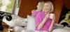 A woman sitting on a couch holding cups.