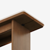 Close-up view of the corner of a wooden table with a smooth finish and round edges, featuring a white layer on the tabletop and a visible screw underneath.