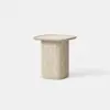 A small, square, beige side table with a flat top and a thick, cylindrical base, made of a stone-like material, set against a plain white background.