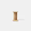 A minimalist wooden stool with a rectangular top and base, connected by a central vertical support, placed on a smooth, light grey surface against a plain white background.