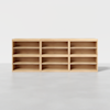 A light wood shelving unit with three columns and two rows, creating six open shelves, standing on a smooth, light gray floor against a plain white background.