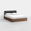 Modern bed with a dark upholstered headboard, white bedding, and a wooden platform base, placed in a minimal, light-colored room.
