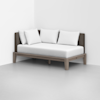 A minimalist daybed with a light wooden frame, brown upholstered backrest, and four white pillows, positioned against a white wall in a modern, empty room with a gray floor.