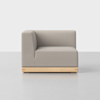 A modern, minimalist armless corner sofa with light gray upholstery and a rectangular wooden base, set against a plain white background.