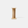 A small, light wood side table with a minimalist design, featuring a rectangular top and base connected by two vertical panels in the center, photographed against a plain white background.
