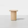 Minimalist wooden side table with a rectangular top and rounded edges, set against a plain white background. The table has a solid, cylindrical base and a smooth, light wood finish.