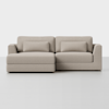 A modern, light beige sectional sofa with chaise lounge on the left, featuring rectangular seat and back cushions, two matching lumbar pillows, and low, wide armrests against a plain white background.