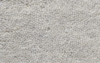 Close-up view of light gray, textured carpet with a soft, looped pile pattern. The surface appears plush and uniform, suitable for flooring in residential or office spaces.