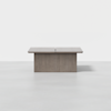 A modern, rectangular wooden table with a split down the center and a solid, wide base, set on a light gray floor with a plain white background.
