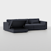 A modern dark gray sectional sofa with a chaise lounge. The chaise has its seat lifted, revealing a hidden storage compartment underneath. The background is plain and light-colored.