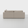 A beige, modern, two-piece sectional sofa is shown from the back against a plain white background. The sofa has clean lines, square arms, and large, plush back cushions.