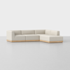 A modern L-shaped sectional sofa with light beige upholstery and a wooden base, set against a plain white background.