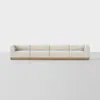 A modern, four-seat sofa with light beige upholstery and a wooden base, set against a plain white background.
