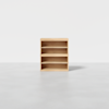 A small, light wood bookshelf with three shelves, standing on a smooth gray floor against a plain white background.