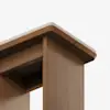 Close-up view of the corner of a wooden table with a light-colored top and smooth, clean lines, highlighting the craftsmanship and natural wood grain against a plain white background.