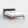 A modern wooden bed frame with a dark upholstered headboard, neatly made with white bedding and two pillows, set in a minimal, light-colored room.