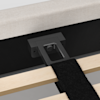 Close-up of a bed frame showing the attachment point where a black metal support leg connects to the frame, with wooden slats and a black fabric strap visible in the foreground.