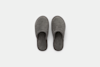 A pair of gray, closed-toe, open-heel slippers made of soft, fuzzy material, shown from above on a plain white background.