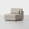 A modern, armless beige upholstered chair with a low back cushion and wide seat, placed on a smooth, light-colored floor against a plain white background.