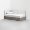 A modern daybed with a wooden base and white upholstered back and side panels is placed in the corner of a minimalist room. The daybed has a white mattress and a single white pillow.