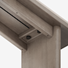 Close-up view of the underside of a wooden table, showing detailed joinery and two black adjustable knobs mounted in a recessed area for assembly or adjustment.