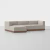 A modern beige sectional sofa with clean lines, low backrest, and wooden base, arranged in an L-shape on a plain light gray floor with a white background.