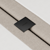 Close-up of a textured beige fabric strap secured with a black metal clip engraved with the word THUMA, against a white background.