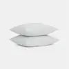 Two plain white pillows are stacked neatly on top of each other against a simple white background.